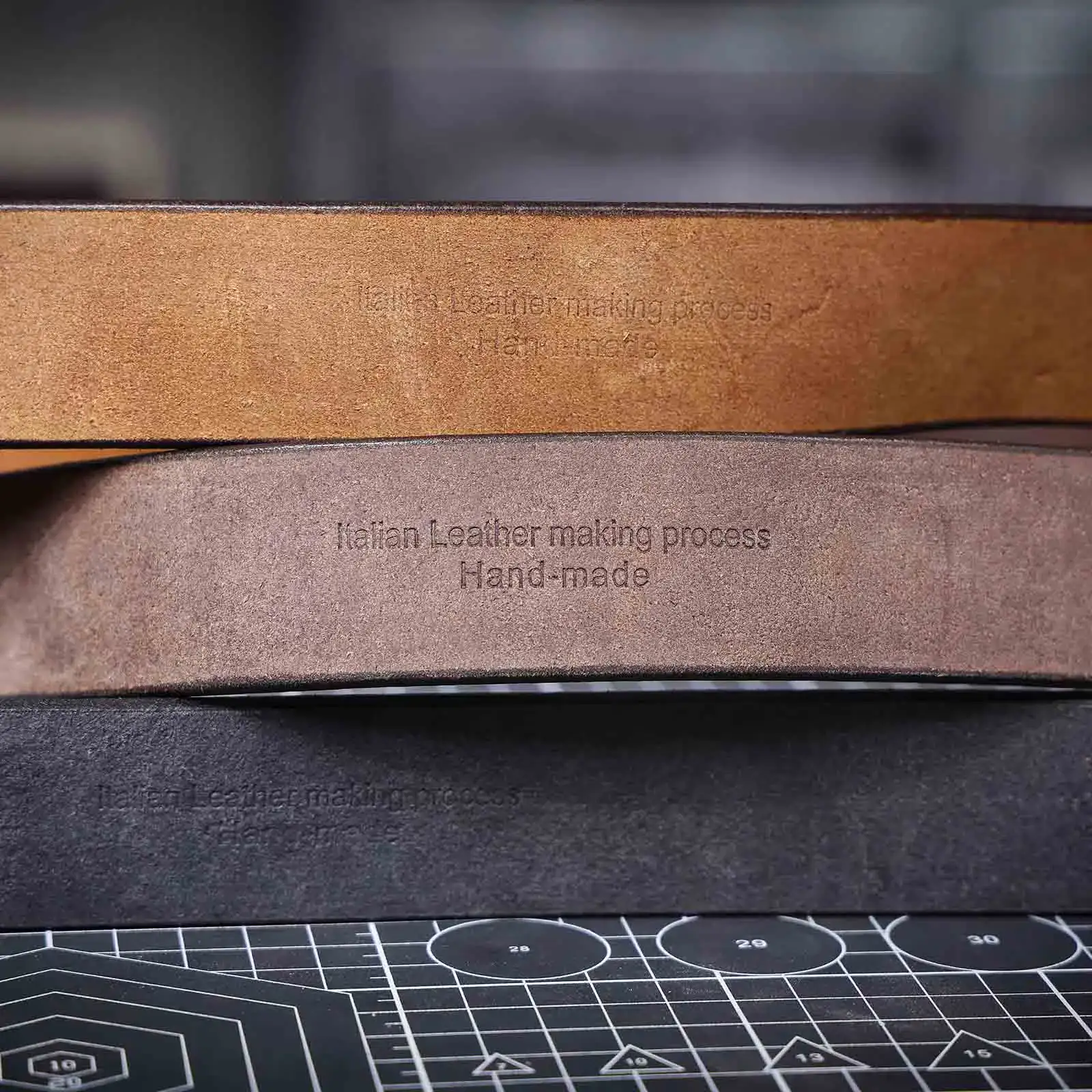 Genuine Leather Men’s Cowhide Belt Close-up of handcrafted genuine leather men's belt in brown, black, and tan.