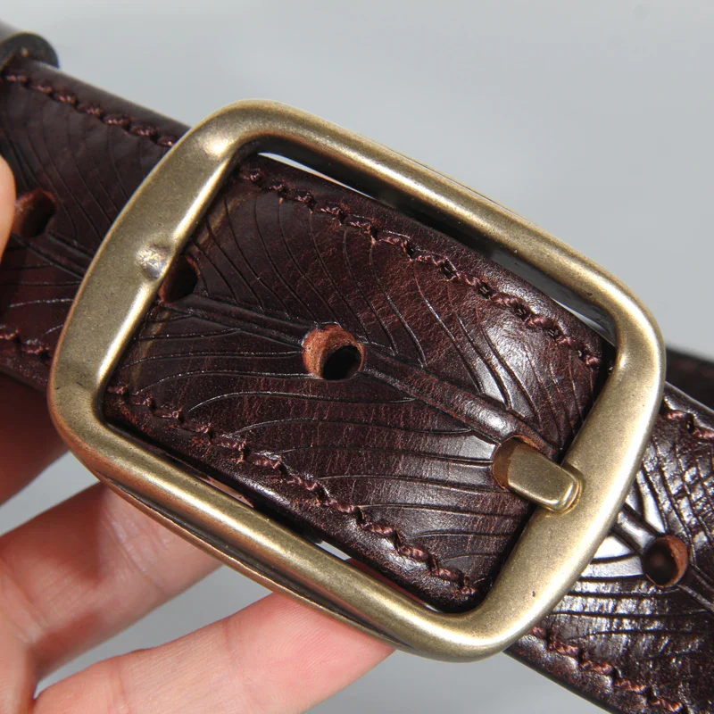 Leather Belt with Embossed Heritage Pattern and Brass Buckle Embossed leather belt featuring a heritage pattern and a brass buckle, perfect for stylish and durab.