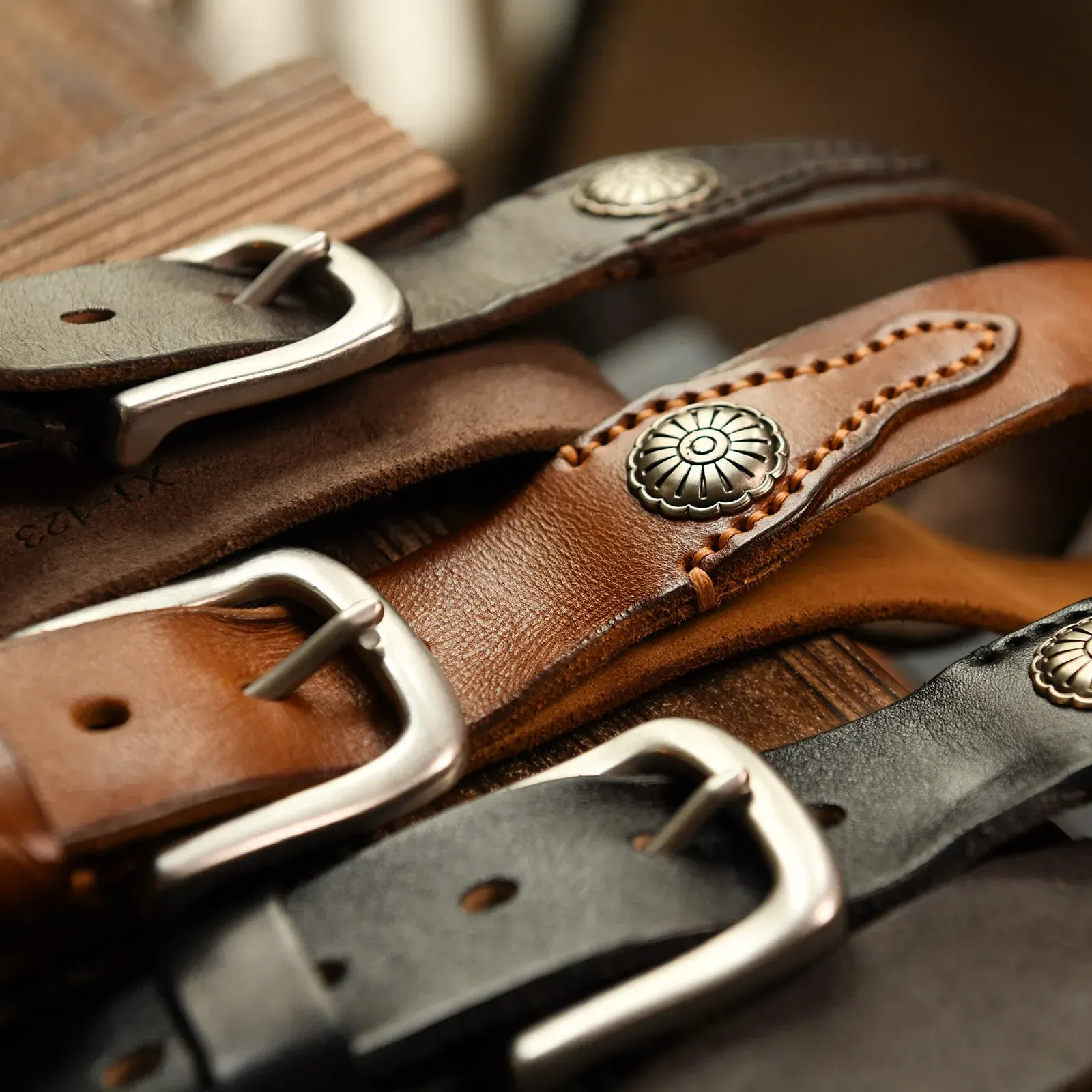 Vintage steel and full-grain leather belts with metal accents and sturdy buckles. High-quality leather belts featuring vintage steel details and durable metal buckles.