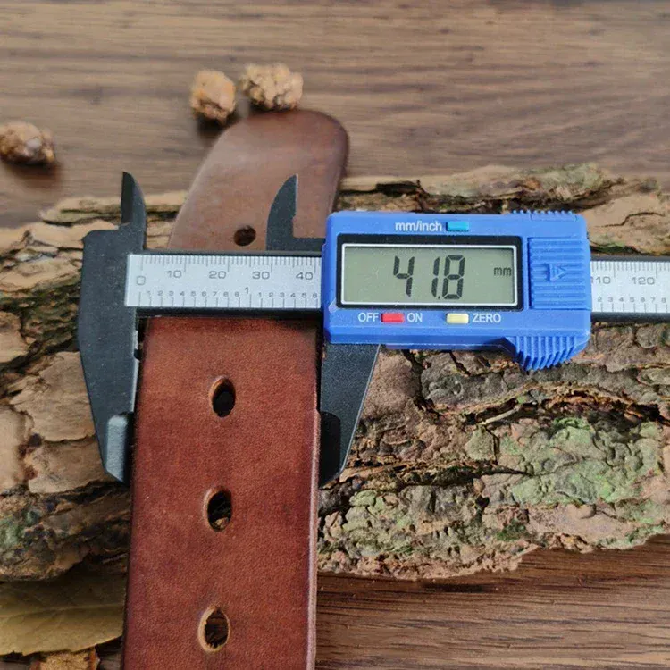 Leather belt with brass buckle measuring 41mm thickness on wood surface. High-quality full-grain leather belt with solid brass buckle for durability.