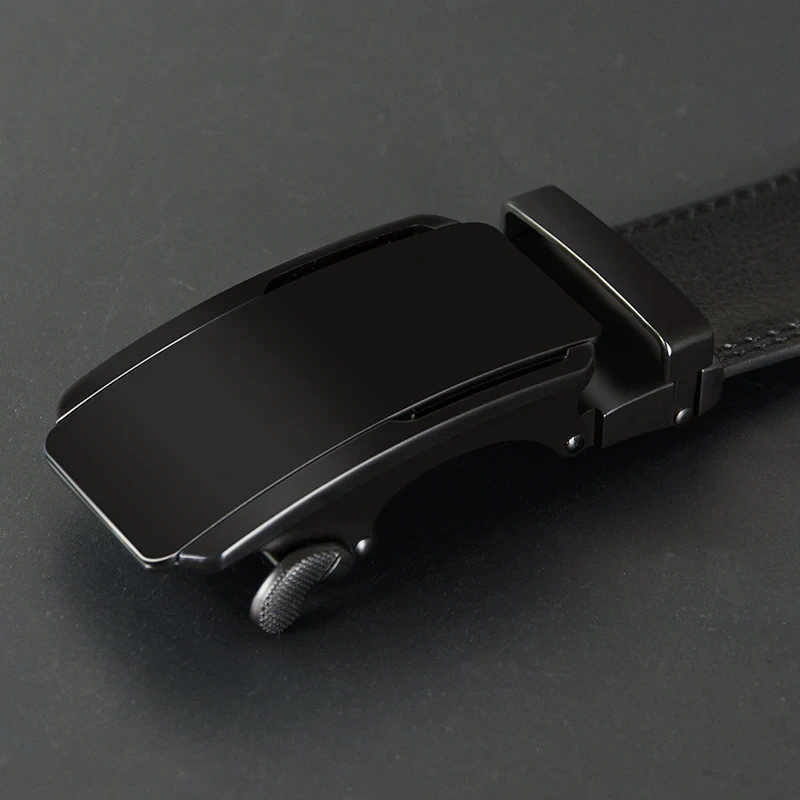 Black ratchet leather belt with sleek buckle for minimalist style. Black ratchet leather belt with minimalist black buckle for modern fashion.