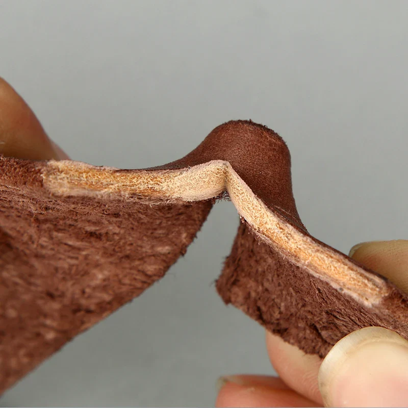 Leather belt with a classic pin buckle, close-up view. Genuine cowhide leather belt with pin buckle, detailed close-up.